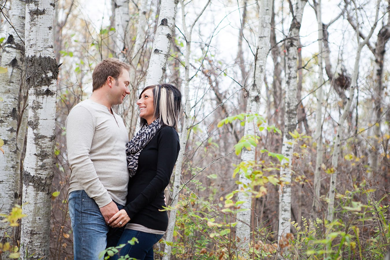 Prince Albert Photographer UBU Photos captures couple posing for a photograph in the forest